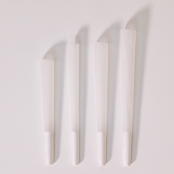 four refined white pre-rolled cones lying on a white background